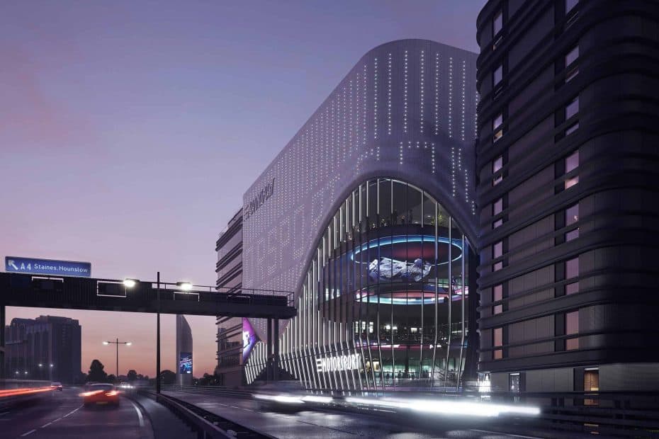 Artist's impression of London Motorsports campus. There is a tall building to the right with a large glass area to the front which features a suspended F1 car and the word ‘motorsport’. Next to it is the M4. You can just see some cars and there is an overhead sign which reads ‘A4 Staines, Hounslow’. In the distance are other high-rise buildings.