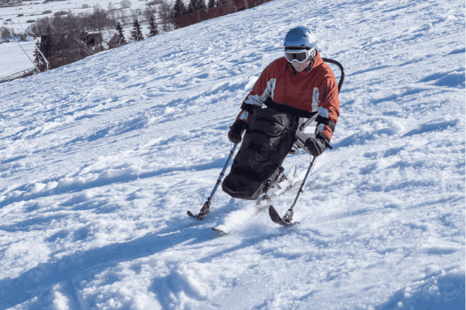 Person skiing downhill using adaptive sit-ski equipment on a snowy slope.